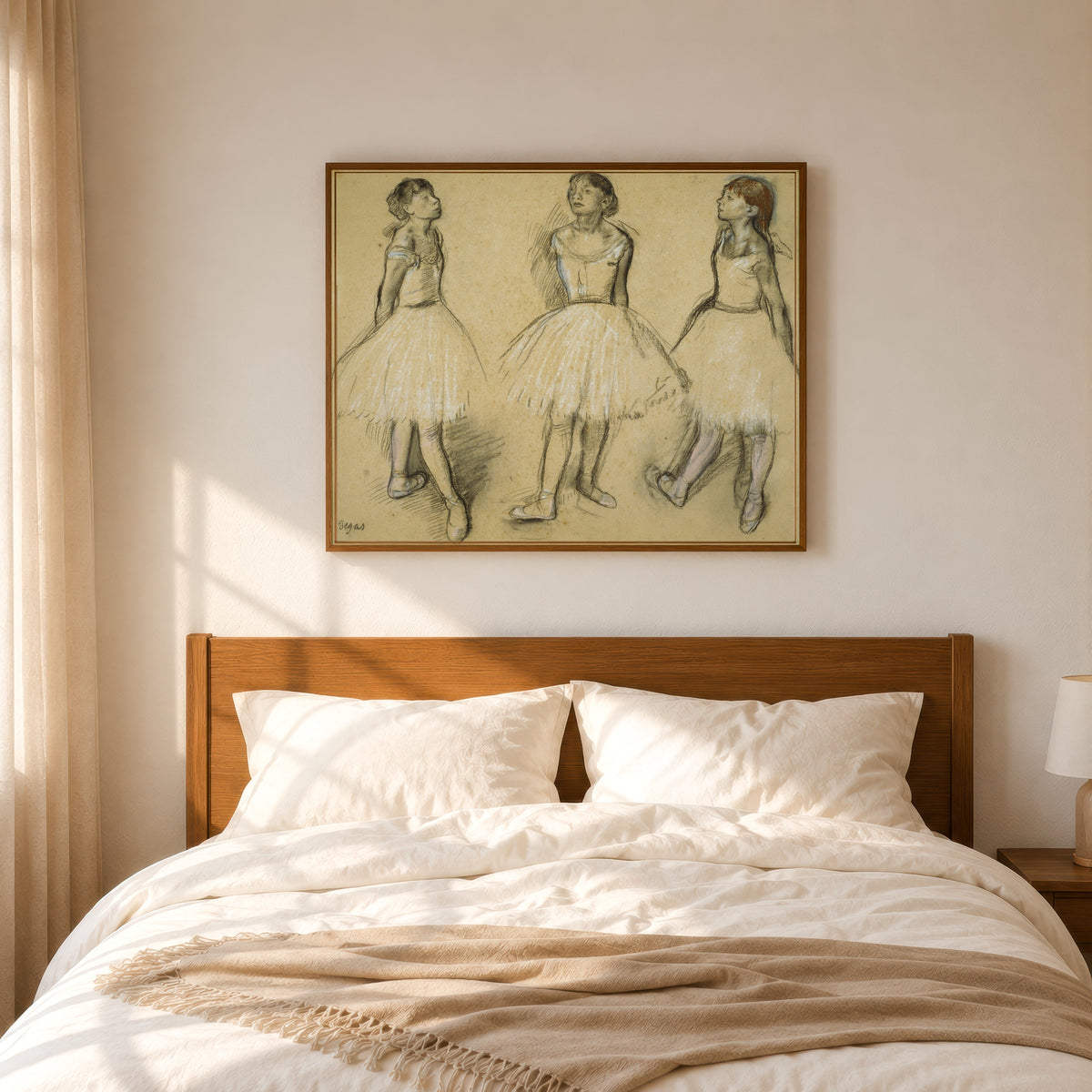 Framed art print of Three Studies of a Dancer in Fourth Position by Edgar Degas, in a slim wood frame above a bed in a sunlit bedroom