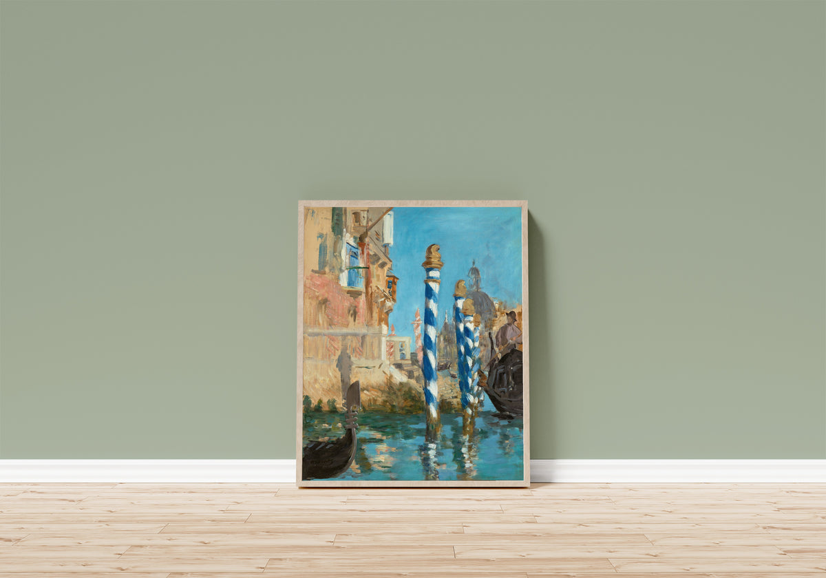Framed art print of Le Grand Canal à Venise by Édouard Manet, in a light wood frame leaning on a sage green wall above a wooden floor