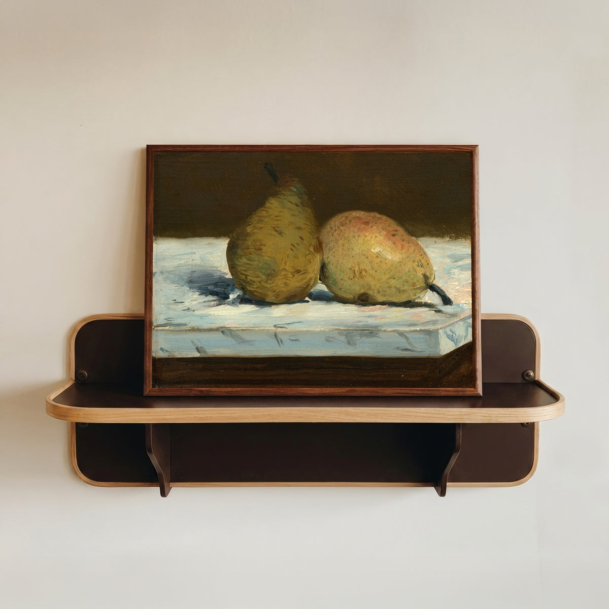 Framed art print of Pears by Édouard Manet, in a dark wood frame resting on a wall shelf