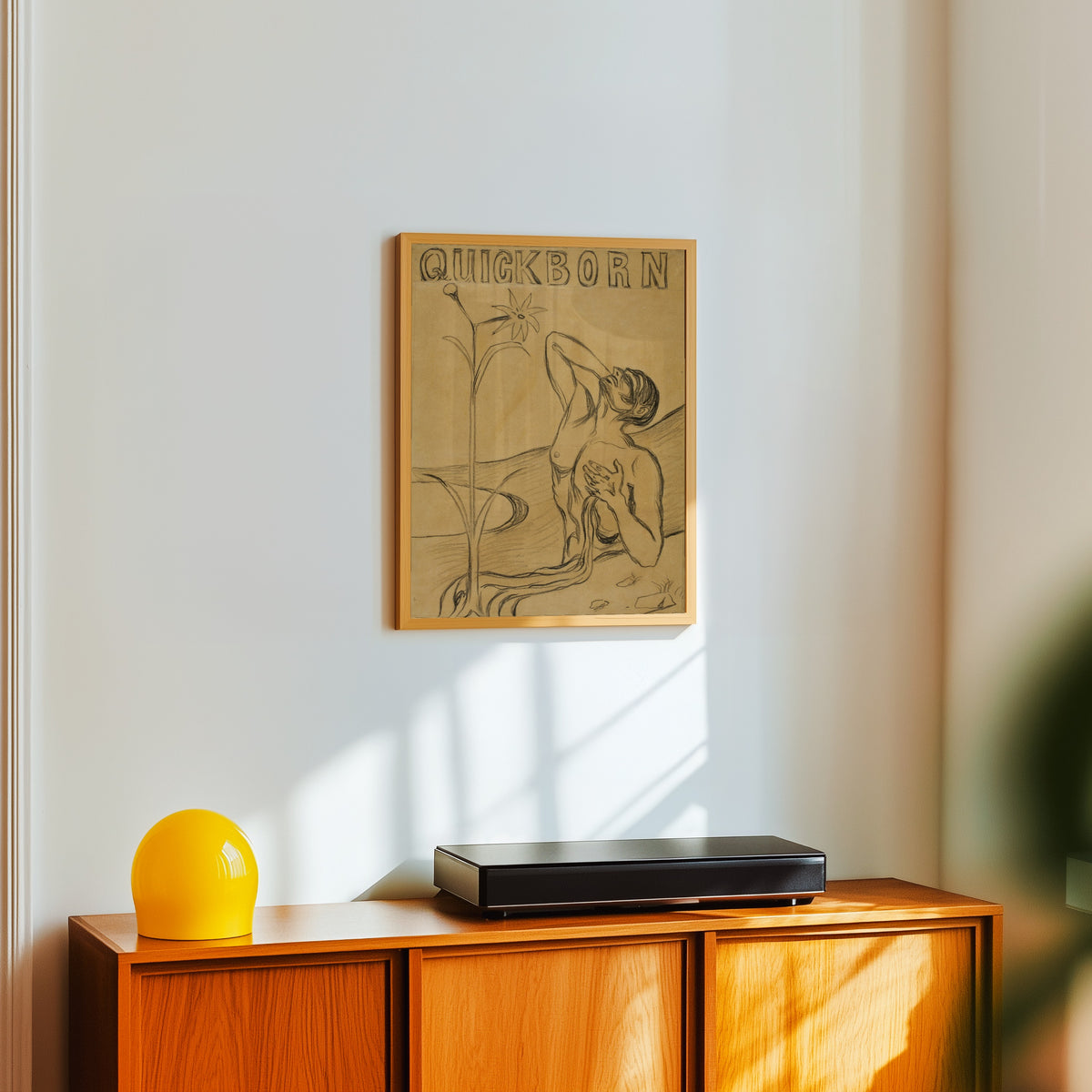 Framed art print of The Flower of Pain by Edvard Munch, in a light wood frame on a white wall above an orange sideboard