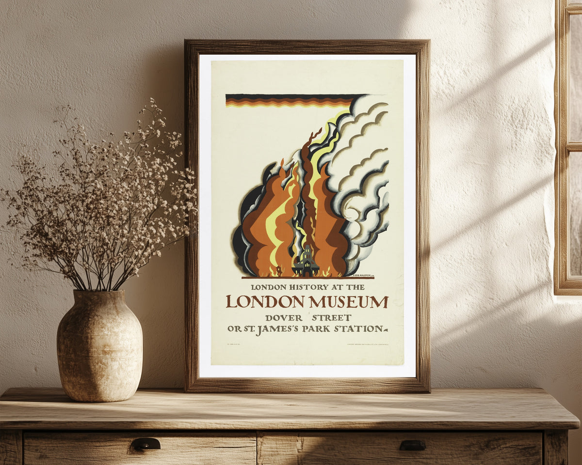 Framed art print of London History at the London Museum by Edward McKnight Kauffer, in a dark wood frame leaning on a rustic console beside dried flowers