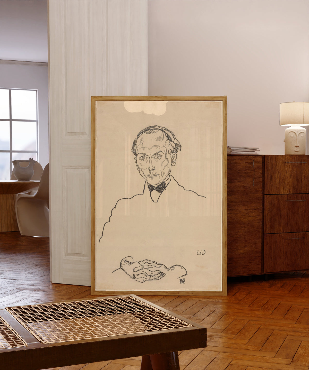 Framed art print of Dr. Ernst Wagner by Egon Schiele, in a light wood frame leaning in a warm room with a parquet floor