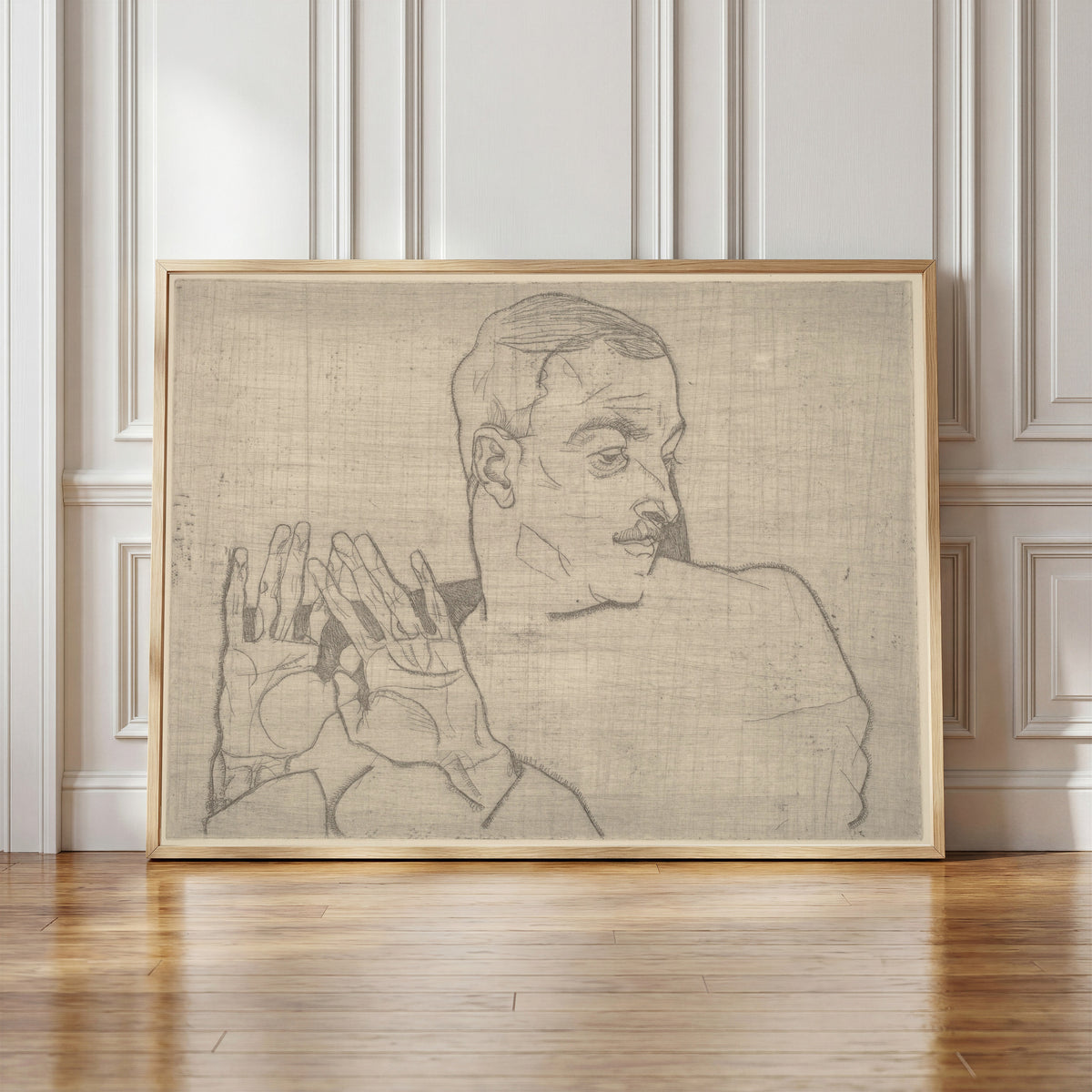 Framed art print of Portrait of Arthur Roessler by Egon Schiele, in a light wood frame leaning against a panelled white wall