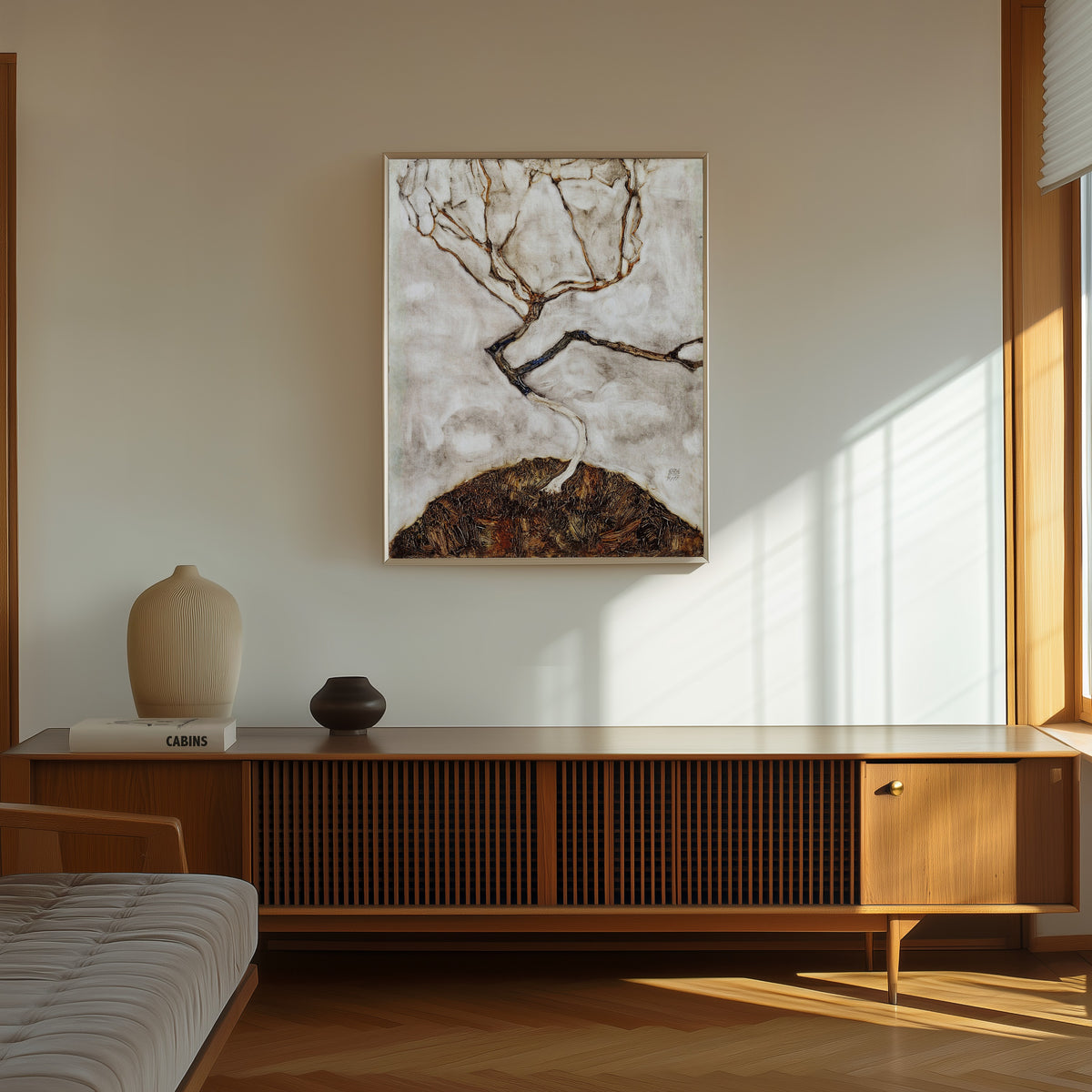 Framed art print of Small Tree in Late Autumn by Egon Schiele, in a thin light frame on a sunlit wall above a wooden sideboard