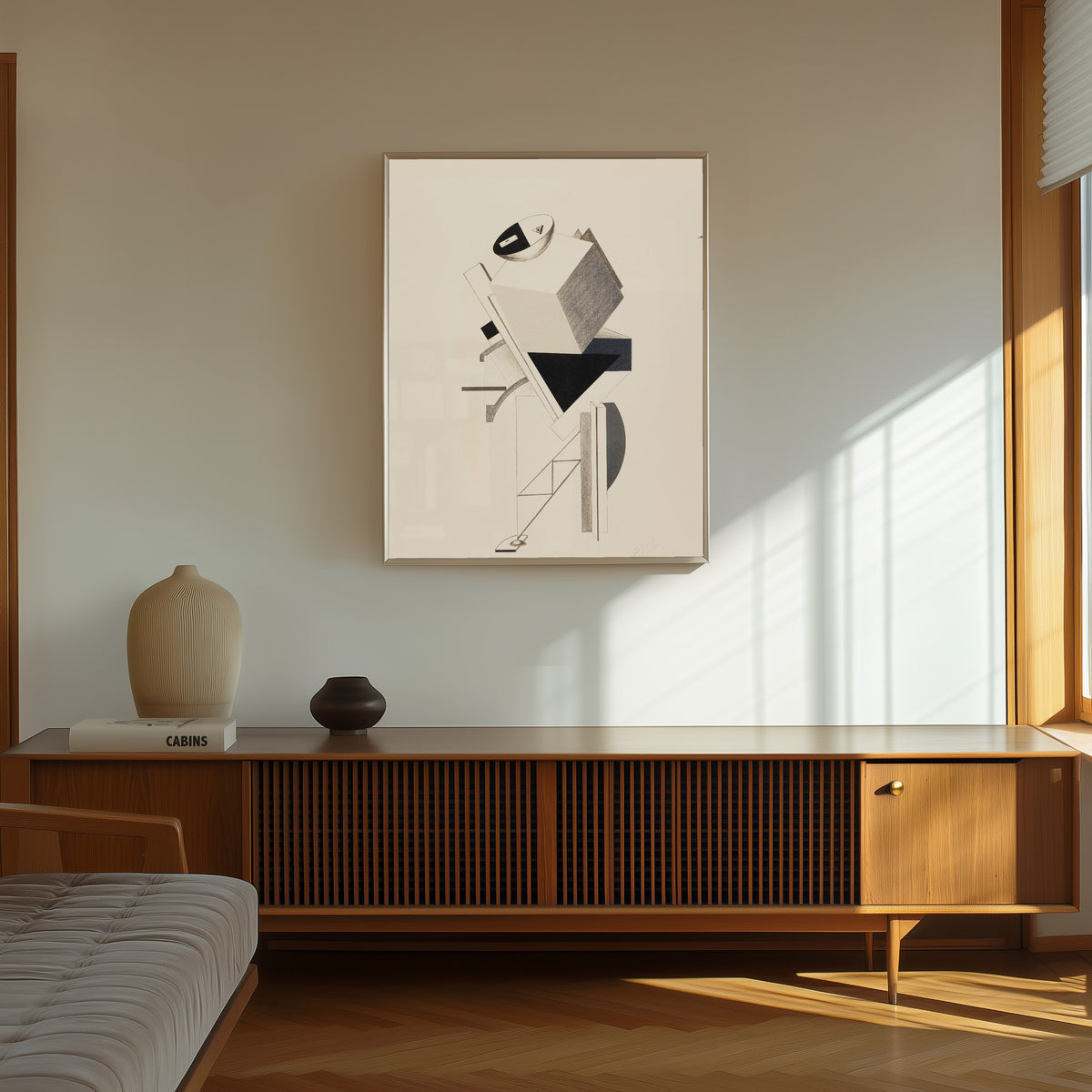 Framed art print of Figurines: The Sentry (Posten) by El Lissitzky, in a thin light frame on a sunlit wall above a wooden sideboard