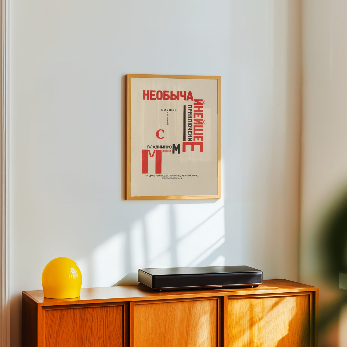 Framed art print of For the Voice: An Extraordinary Adventure (Title Page) by El Lissitzky, in a light wood frame on a white wall above an orange sideboard
