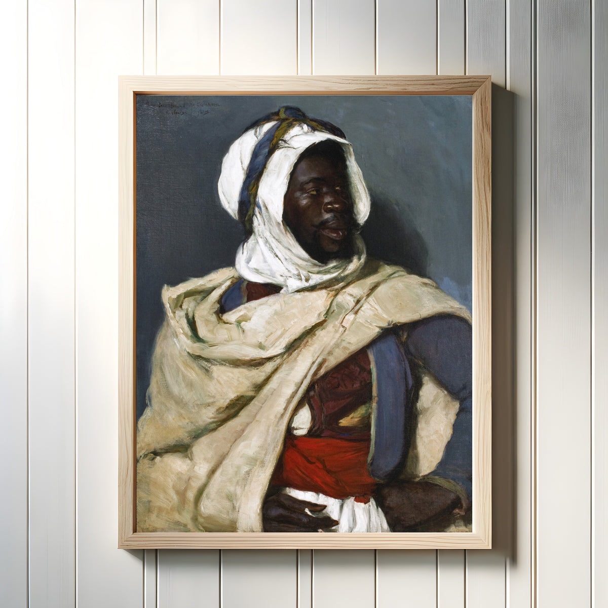 Framed art print of An Algerian Man by Elizabeth Nourse, in a light wood frame on a white panelled wall