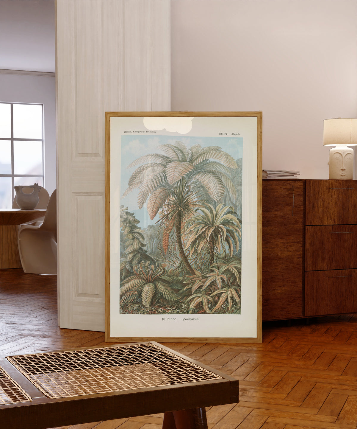 Framed art print of Kunstformen der Natur, Plate 92: Filicinae by Ernst Haeckel, in a light wood frame leaning in a warm room with a parquet floor