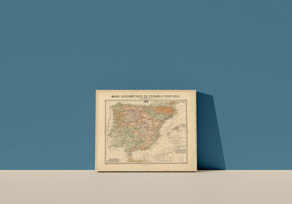Framed art print of Mapa hipsométrico de España y Portugal by Federico de Botella y de Hornos, in a light wood frame leaning on a blue wall