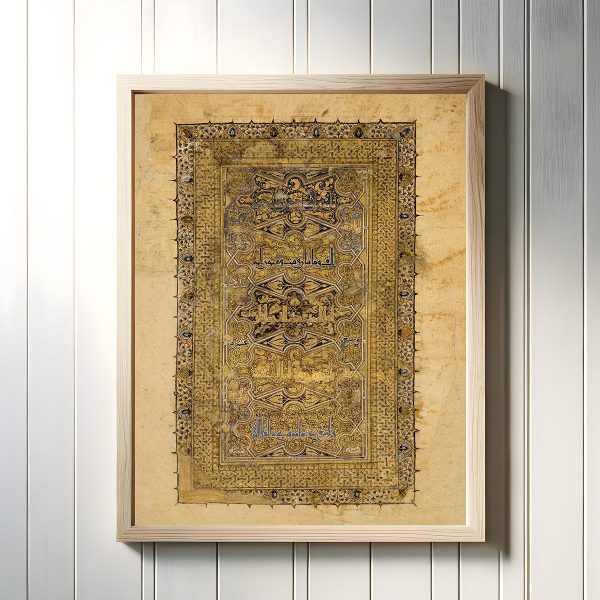 Framed art print of Folio from a Qur'an Manuscript by Muhammad al-Zanjani, in a light wood frame on a white panelled wall
