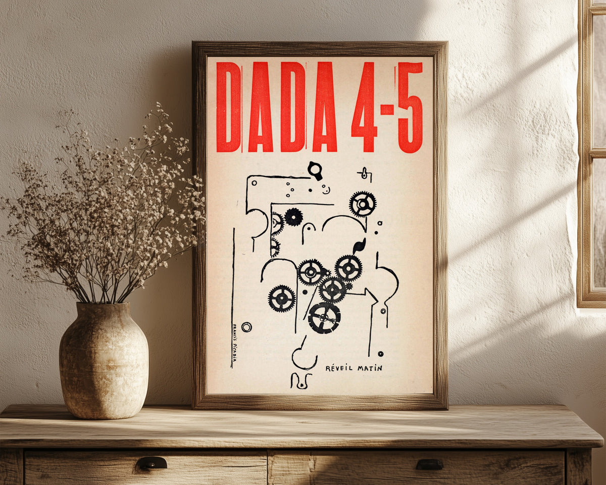 Framed art print of Da-da 4-5 by Francis Picabia, in a dark wood frame leaning on a rustic console beside dried flowers