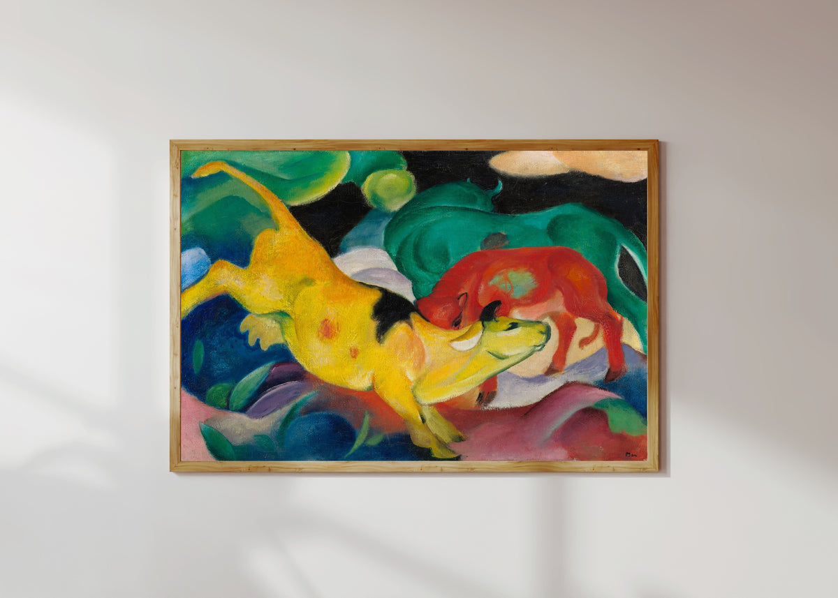 Framed art print of Cows, Red, Green, Yellow by Franz Marc, in a light wood frame on a sunlit white wall