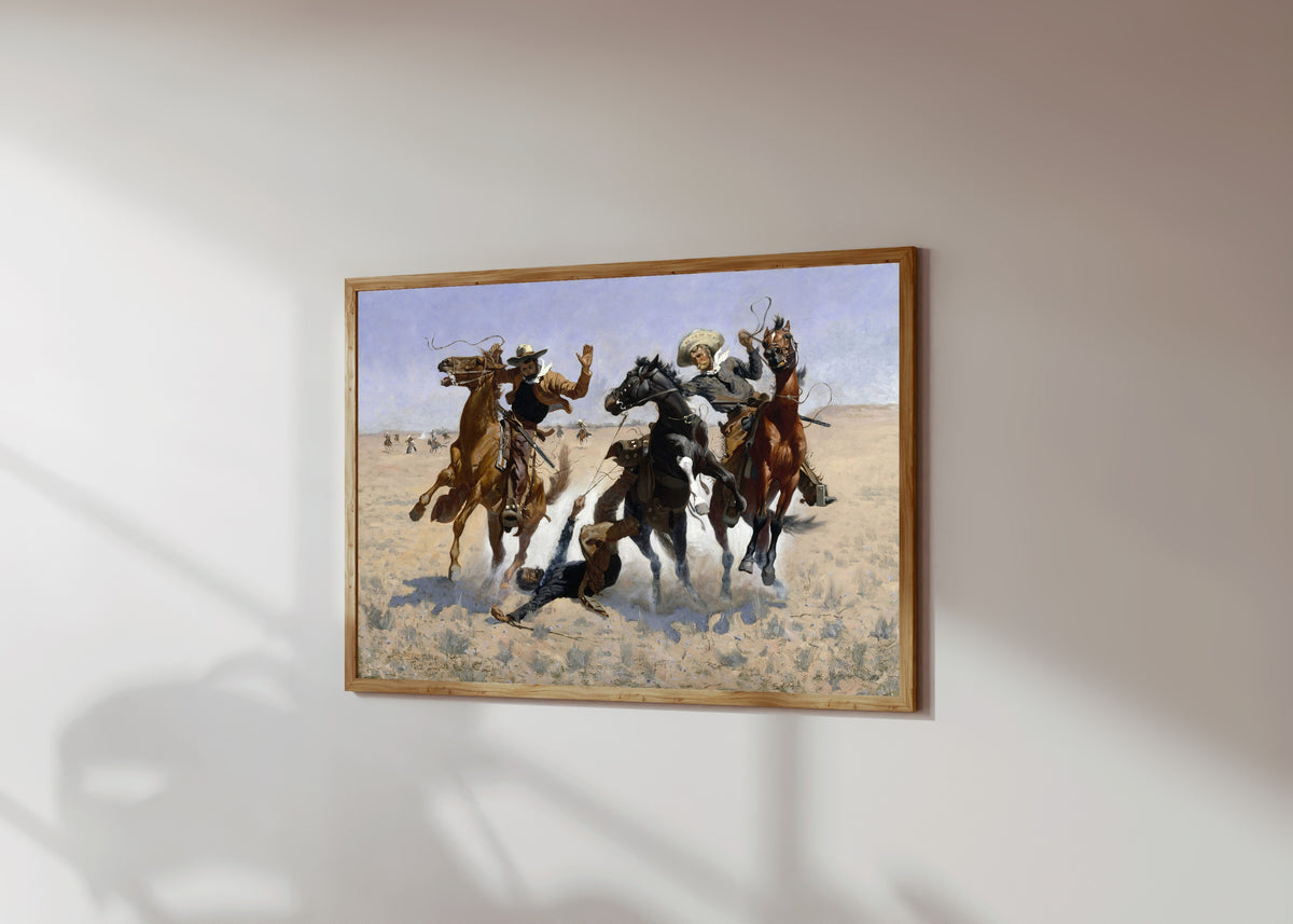 Framed art print of Aiding a Comrade by Frederic Remington, in a light wood frame on a sunlit white wall, seen at a slight angle