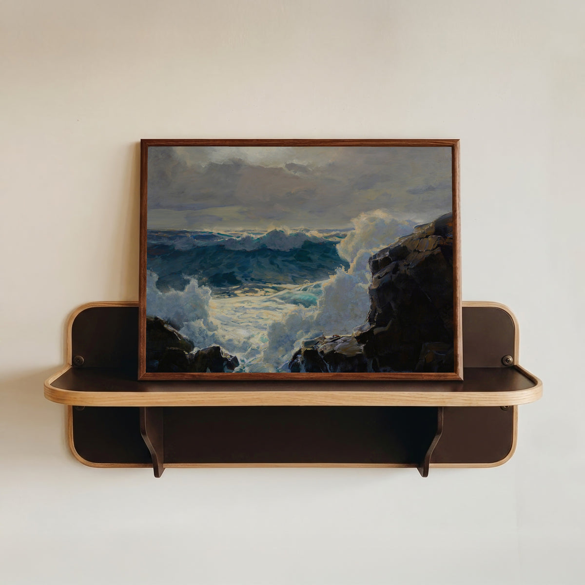 Framed art print of Breaking Waves by Frederick Judd Waugh, in a dark wood frame resting on a wall shelf