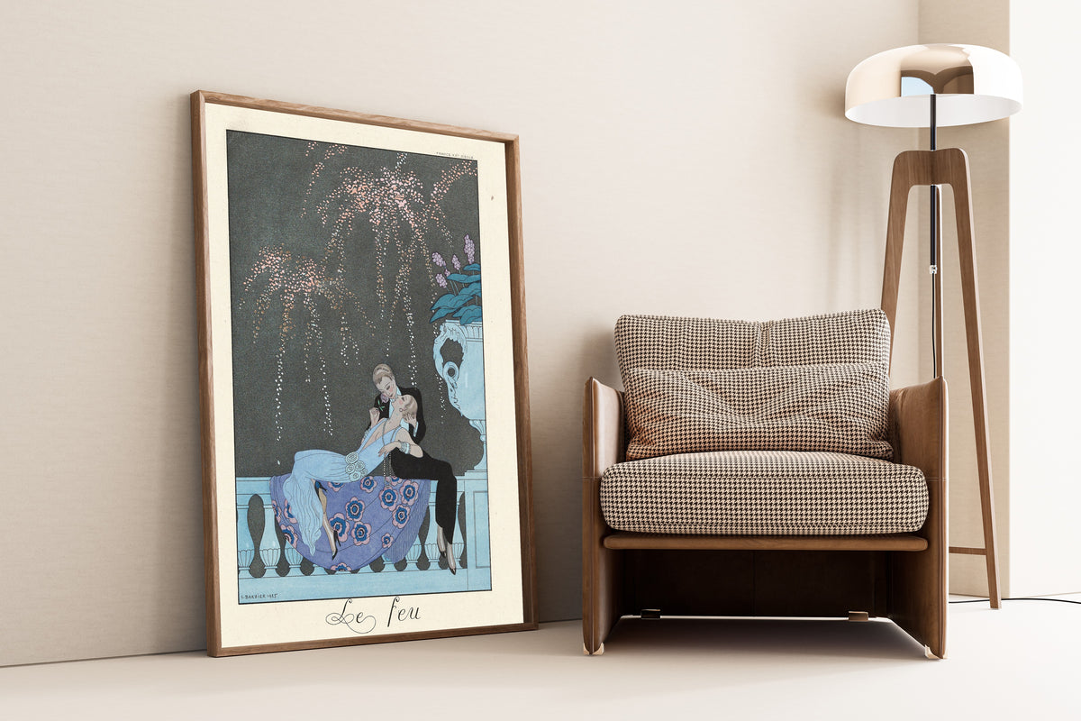 Le Feu by George Barbier — framed and leaning against a wall beside an armchair and a floor lamp