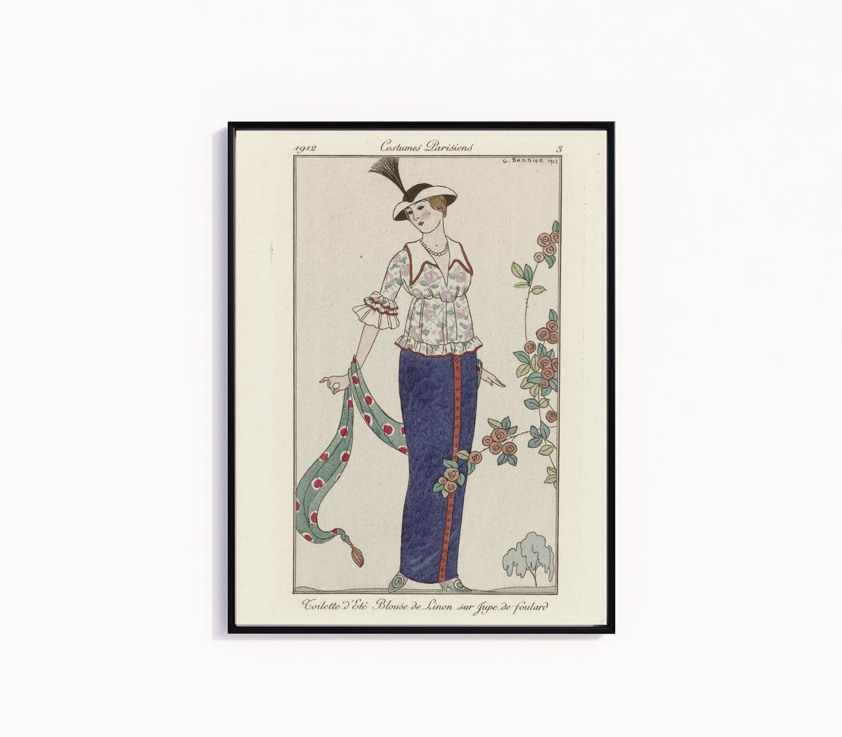 Framed art print of Toilette d'été, blouse de linon sur jupe de foulard [Summer lawn blouse and… by George Barbier, in a slim black frame on a plain white wall