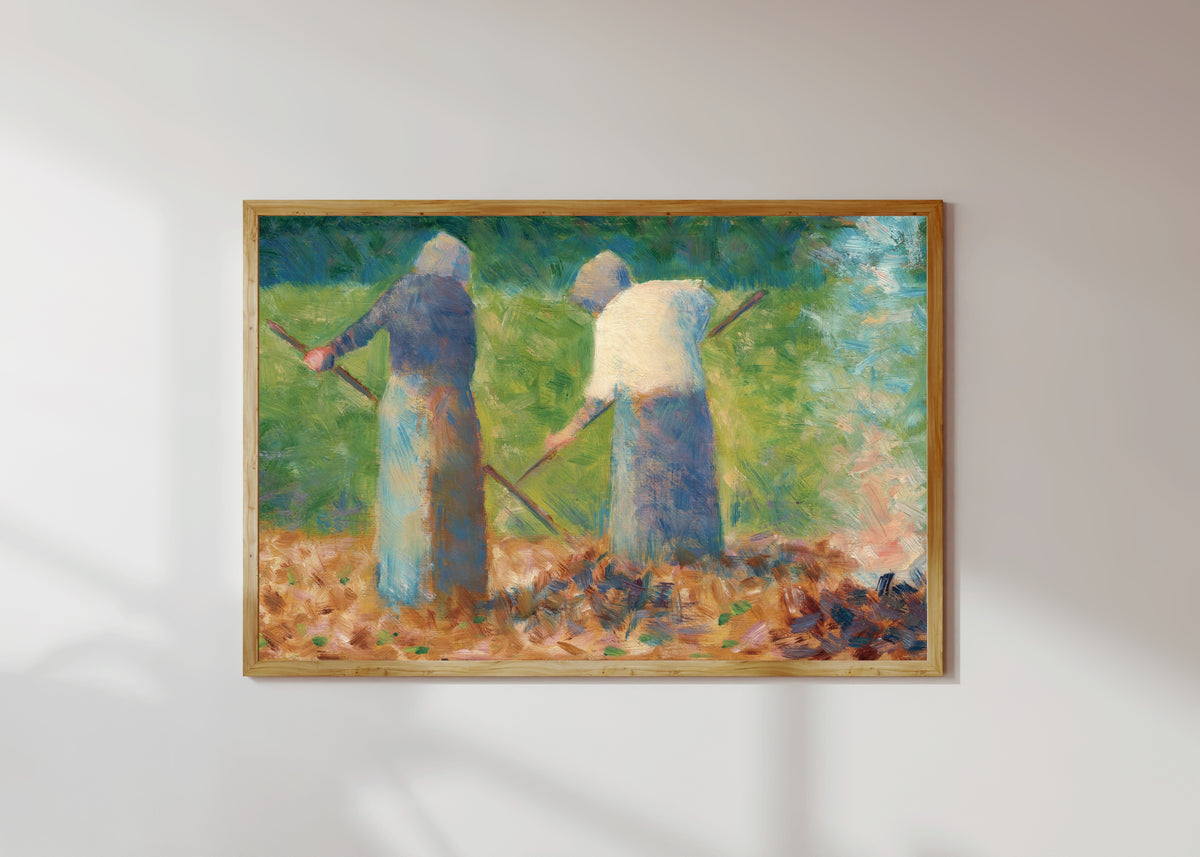 Framed art print of Haymakers at Montfermeil by Georges Seurat, in a light wood frame on a sunlit white wall