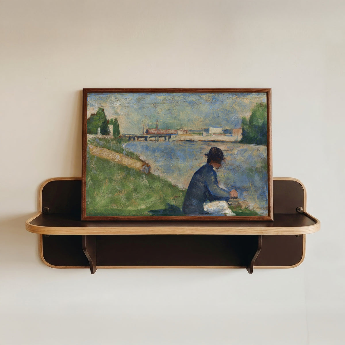 Framed art print of Study for "Bathers at Asnières" by Georges Seurat, in a dark wood frame resting on a wall shelf