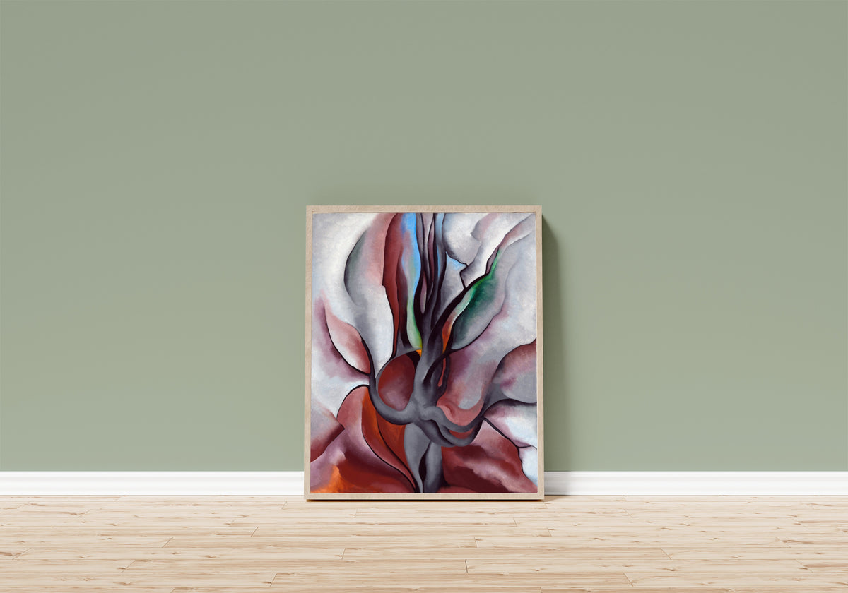 Framed art print of Autumn Trees by Georgia O'Keeffe, in a light wood frame leaning on a sage green wall above a wooden floor