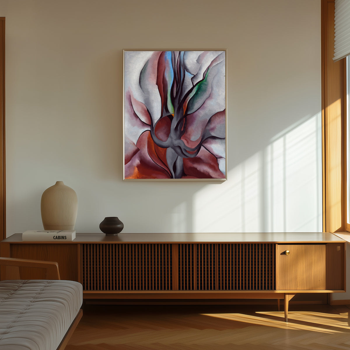 Framed art print of Autumn Trees by Georgia O'Keeffe, in a thin light frame on a sunlit wall above a wooden sideboard
