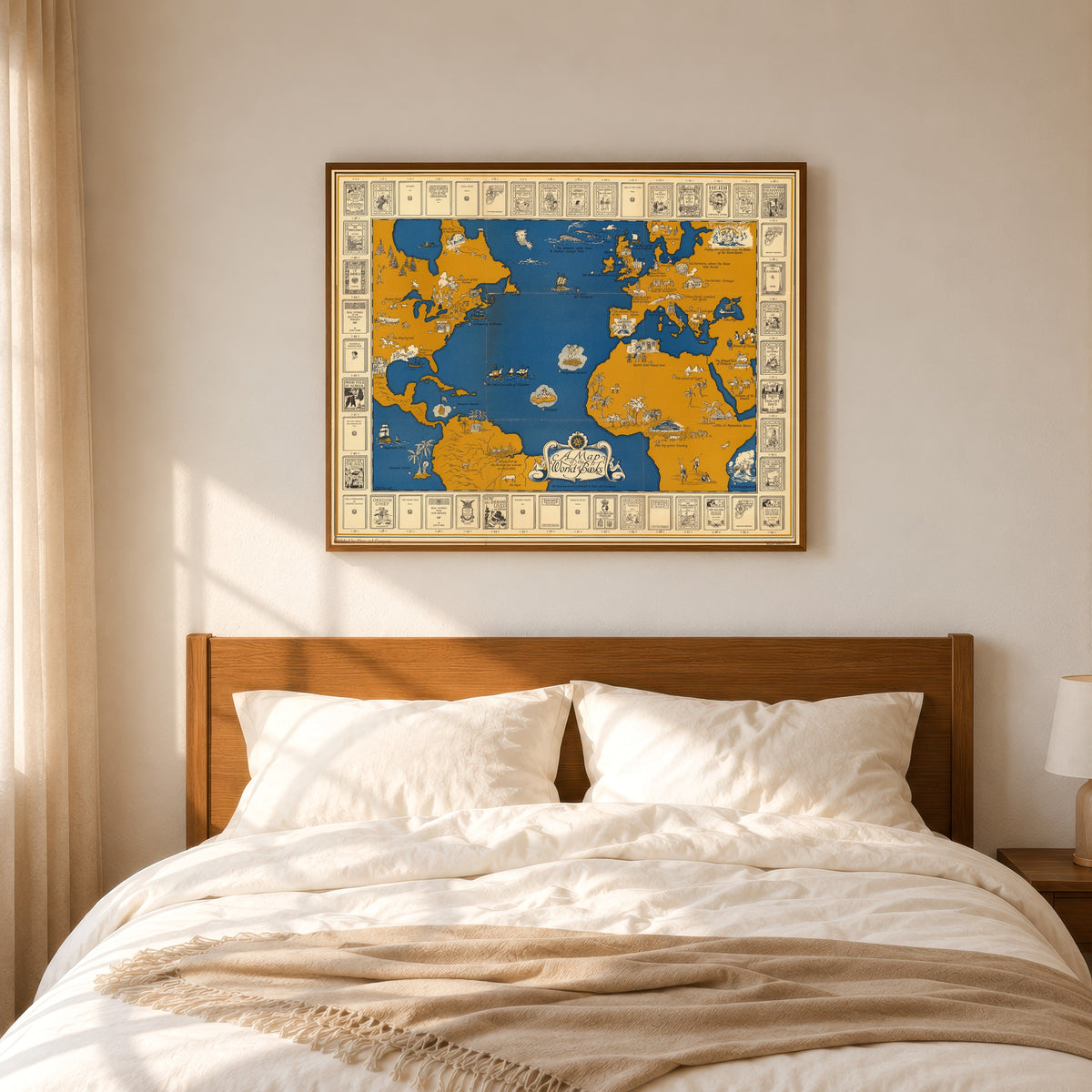 Framed art print of A Map of the World of Books by Ginn and Company, in a slim wood frame above a bed in a sunlit bedroom