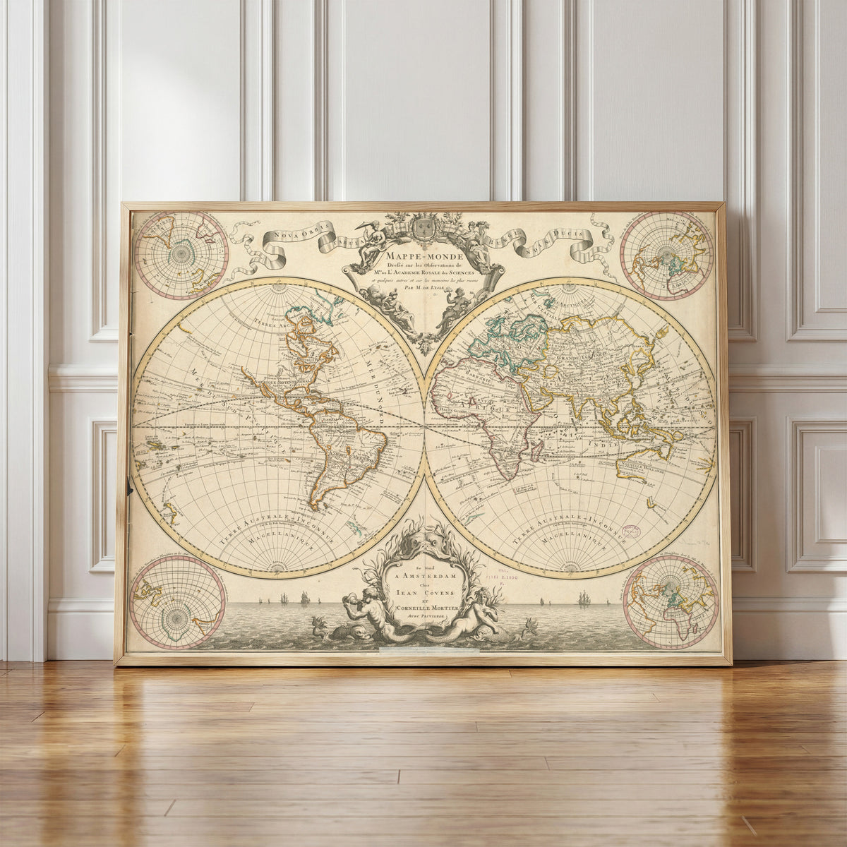Framed art print of Mappe-Monde by Guillaume Delisle, in a light wood frame leaning against a panelled white wall