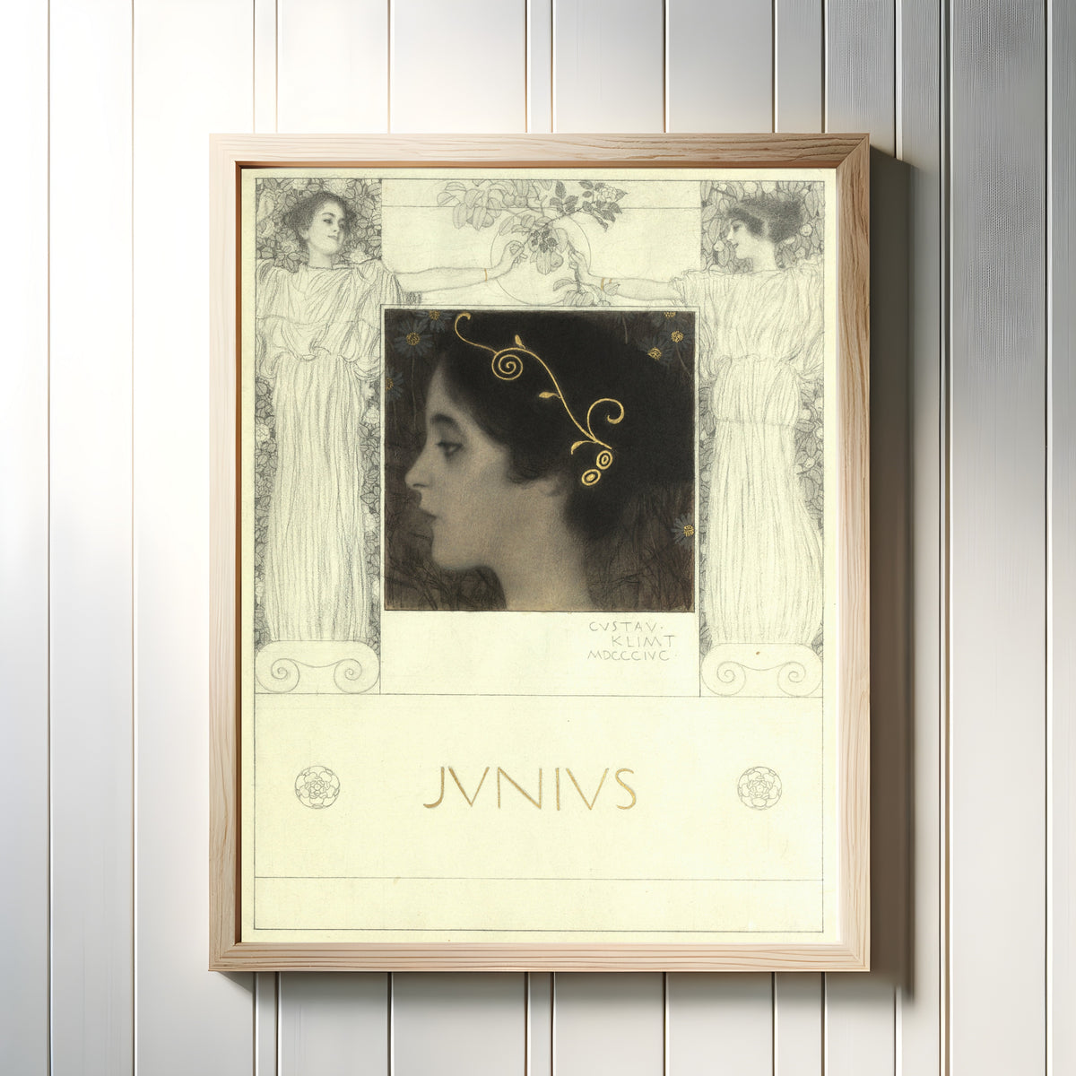 Framed art print of Junius by Gustav Klimt, in a light wood frame on a white panelled wall