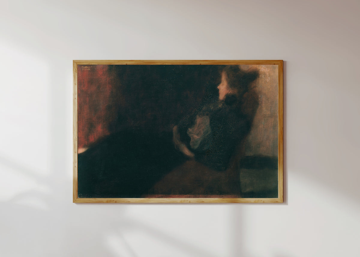 Framed art print of Lady by the Fireplace (Dame am Kamin) by Gustav Klimt, in a light wood frame on a sunlit white wall