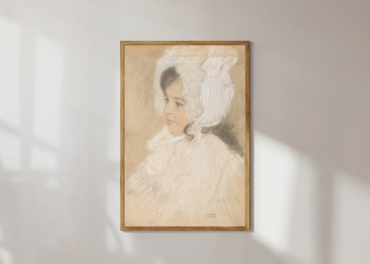 Framed art print of Portrait of a Child (Marie Moll) by Gustav Klimt, in a light wood frame on a sunlit white wall