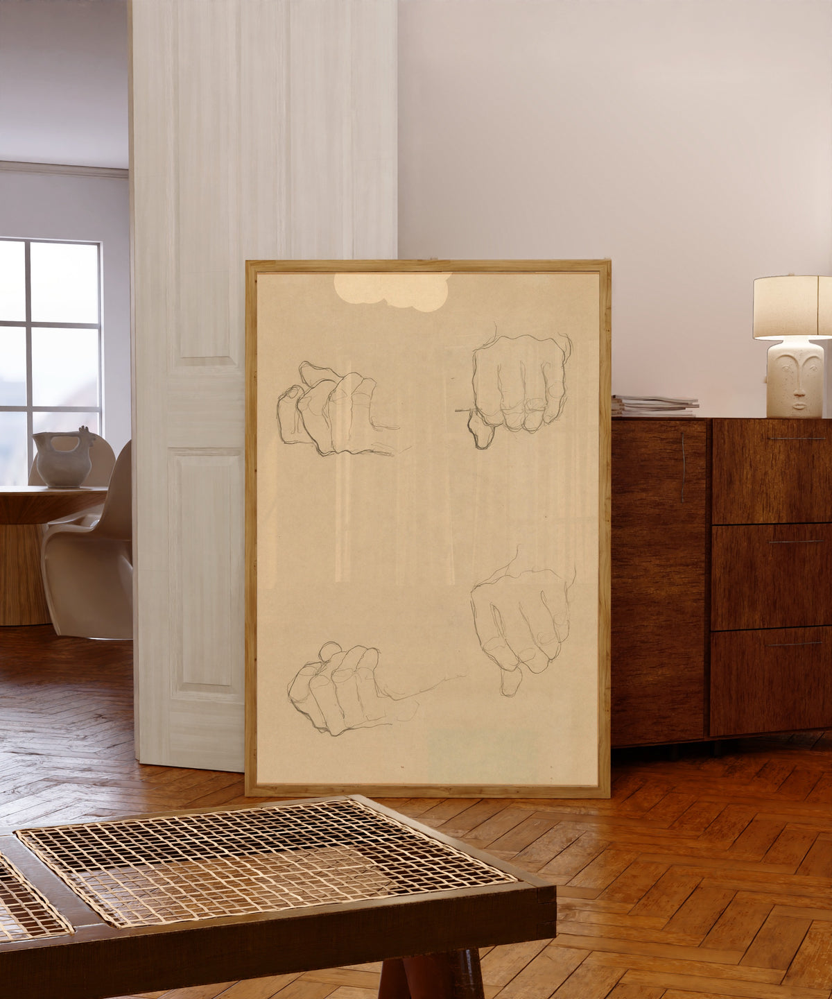 Framed art print of Study of Hands by Gustav Klimt, in a light wood frame leaning in a warm room with a parquet floor
