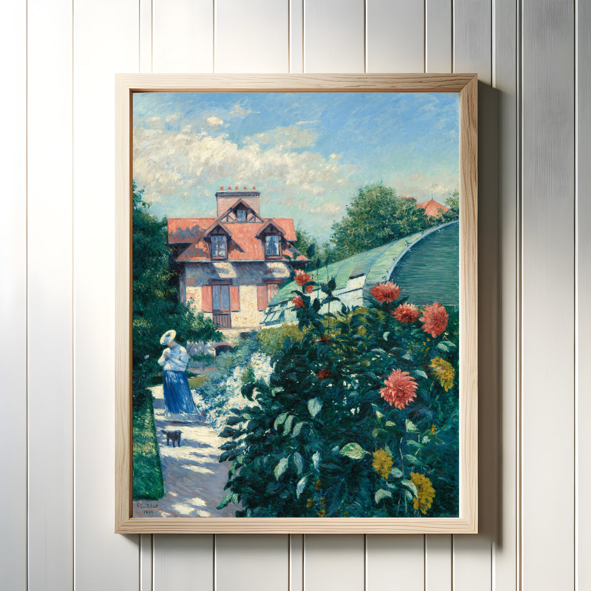Framed art print of Dahlias, Garden at Petit Gennevilliers by Gustave Caillebotte, in a light wood frame on a white panelled wall