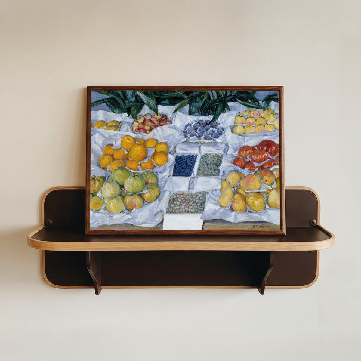 Framed art print of Fruit Displayed on a Stand by Gustave Caillebotte, in a dark wood frame resting on a wall shelf