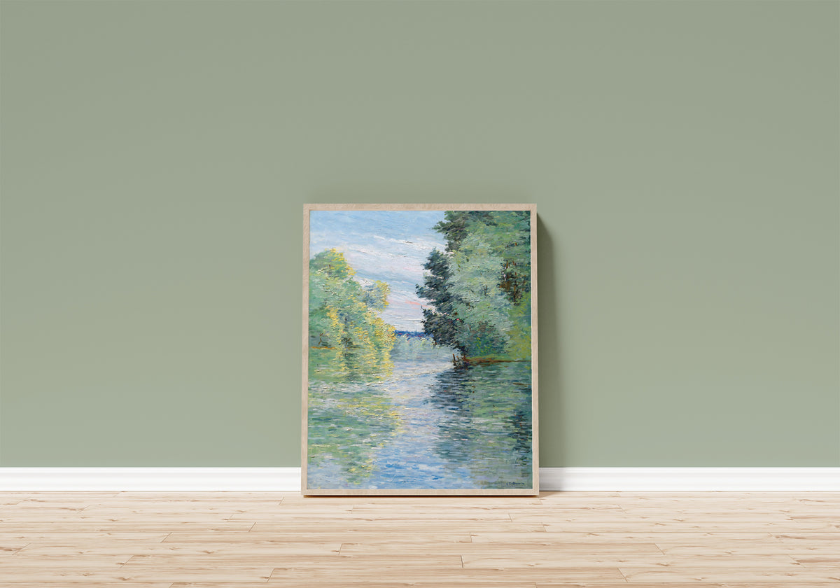 Framed art print of Le Petit bras de la Seine à Argenteuil by Gustave Caillebotte, in a light wood frame leaning on a sage green wall above a wooden floor