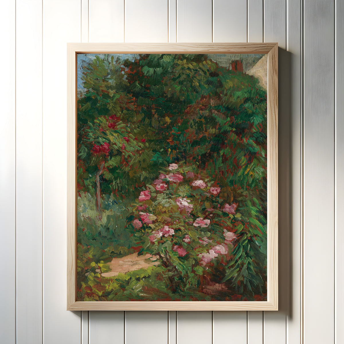 Framed art print of Massif de fleurs, jardin du Petit Gennevilliers by Gustave Caillebotte, in a light wood frame on a white panelled wall