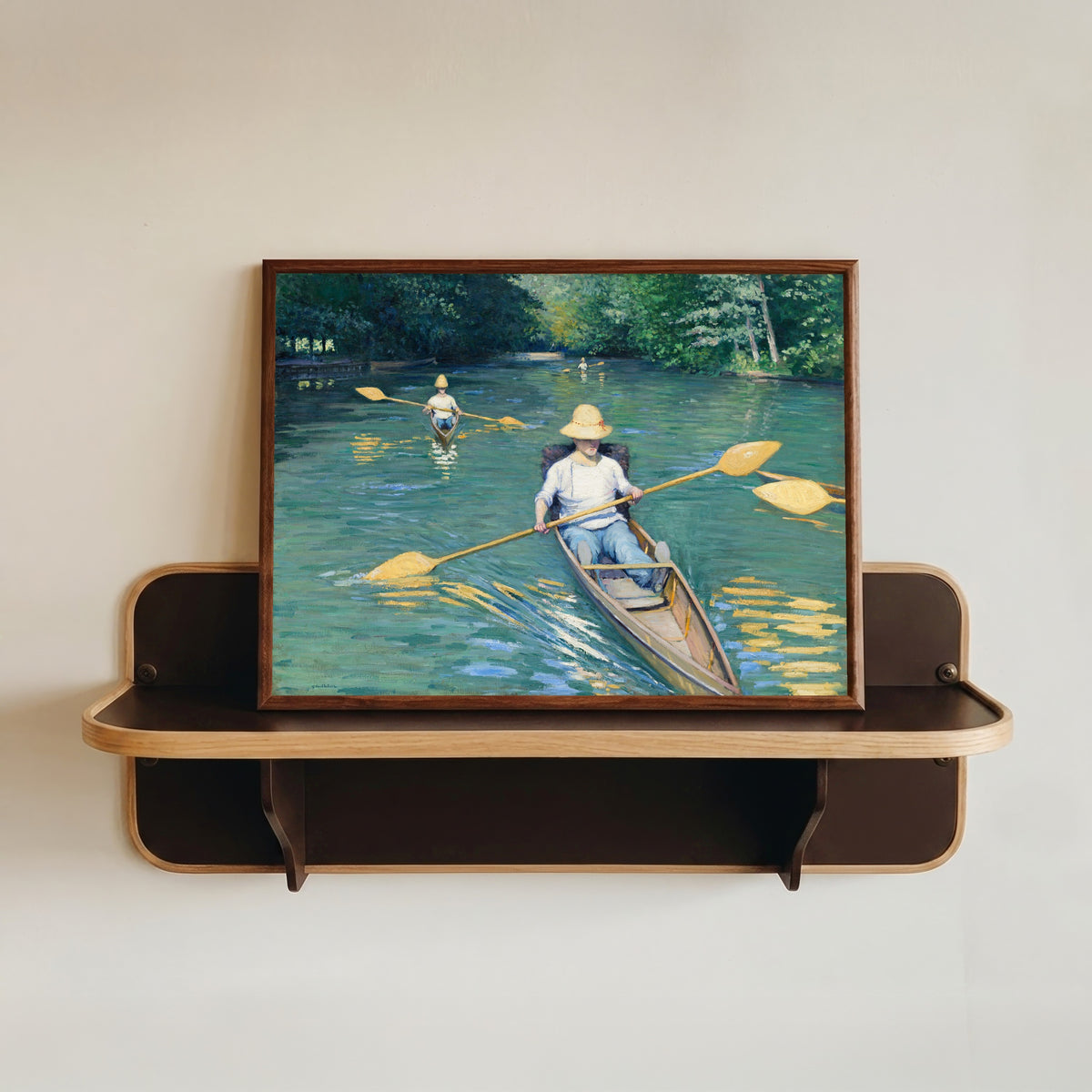 Framed art print of Skiffs by Gustave Caillebotte, in a dark wood frame resting on a wall shelf