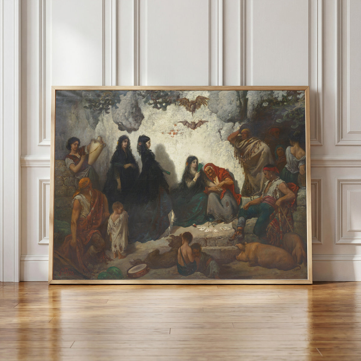 Framed art print of Fortune-Telling at Sacro Monte by Gustave Doré, in a light wood frame leaning against a panelled white wall