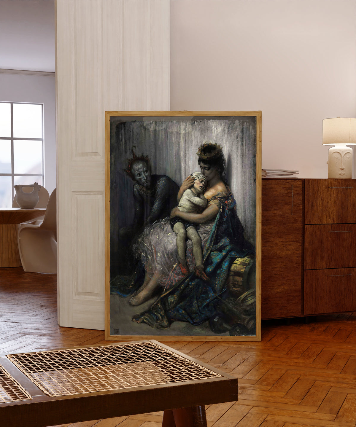 Framed art print of The Acrobat’s Family: The Injured Child by Gustave Doré, in a light wood frame leaning in a warm room with a parquet floor