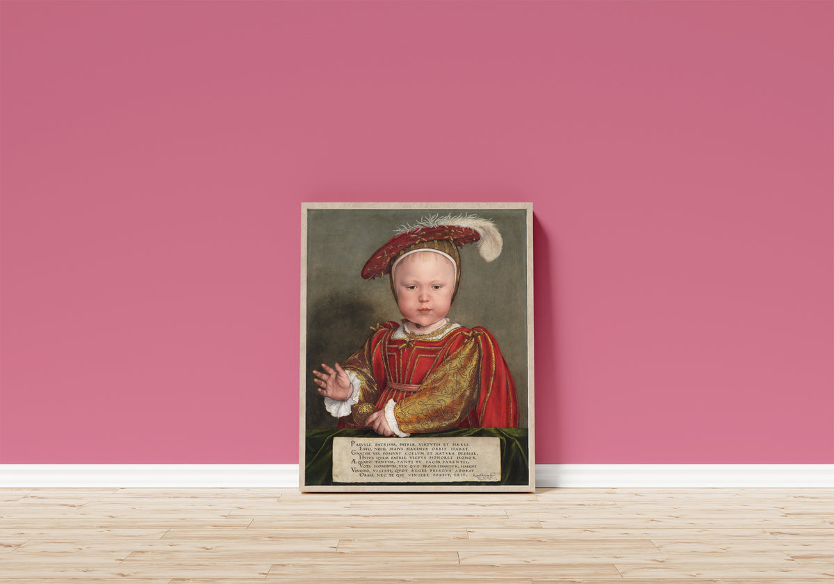 Framed art print of Edward VI as a Child by Hans Holbein the Younger, in a light wood frame leaning on a pink wall above a wooden floor