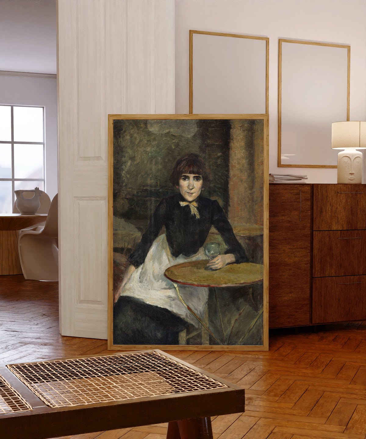 Framed art print of A la Bastille (Jeanne Wenz) by Henri de Toulouse-Lautrec, in a light wood frame leaning in a warm room with a parquet floor