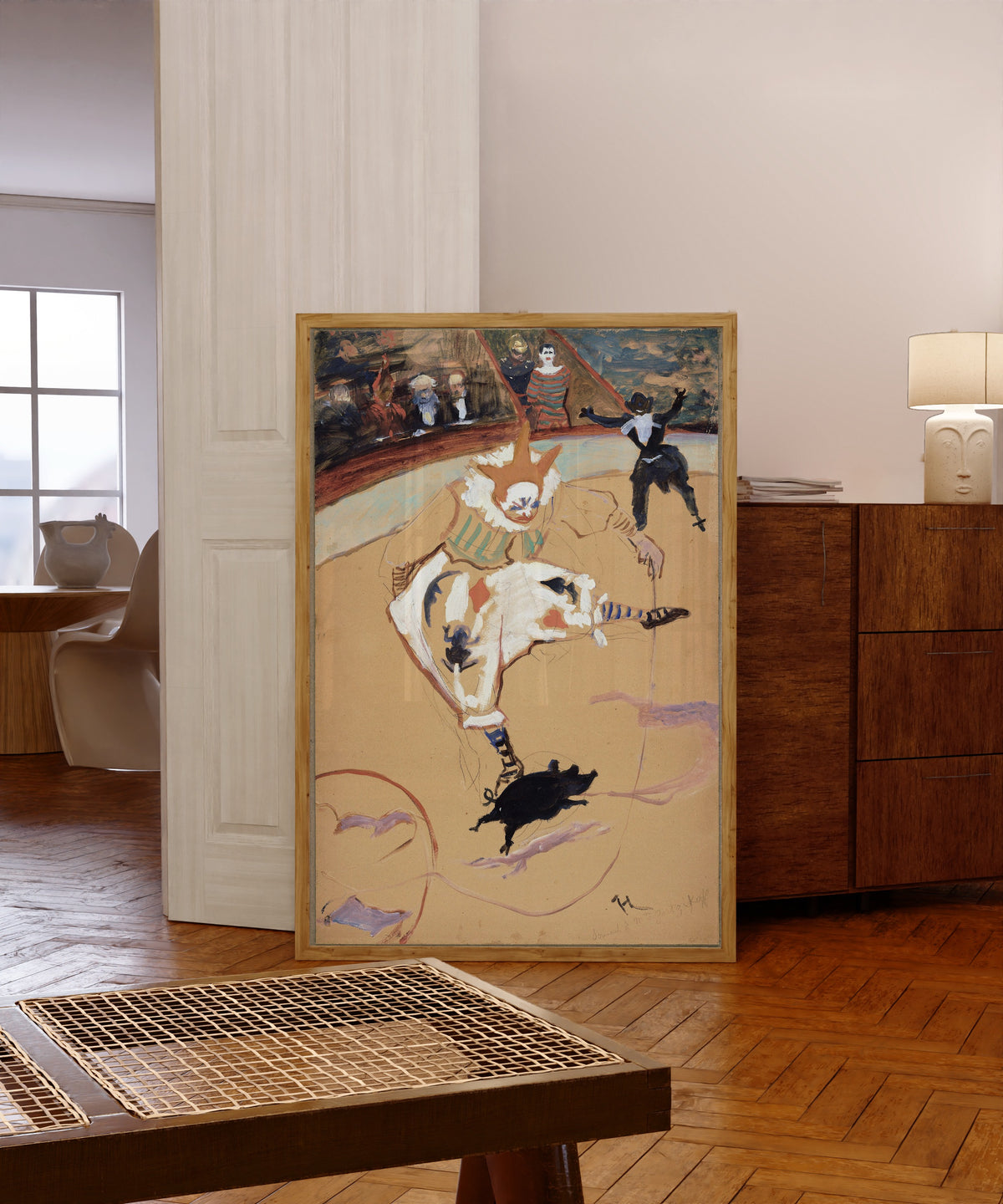 Framed art print of At the Circus Fernando: Medrano with a… by Henri de Toulouse-Lautrec, in a light wood frame leaning in a warm room with a parquet floor