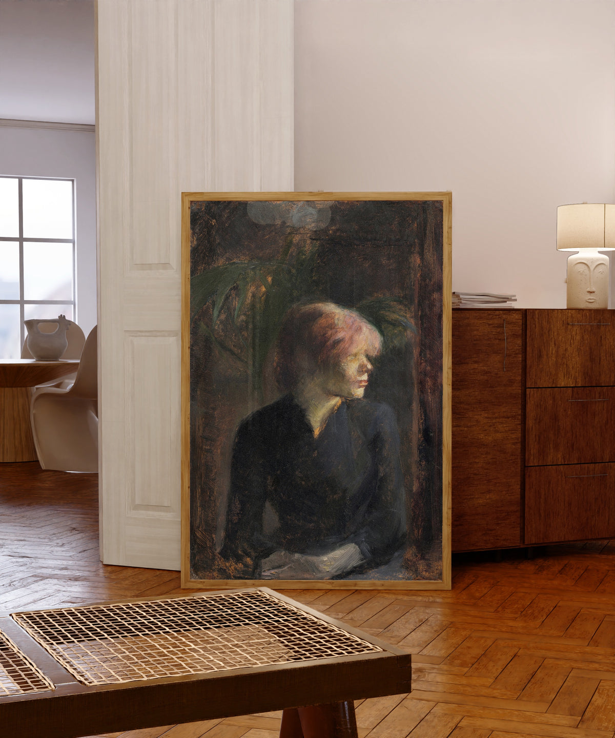 Framed art print of Carmen Gaudin by Henri de Toulouse-Lautrec, in a light wood frame leaning in a warm room with a parquet floor