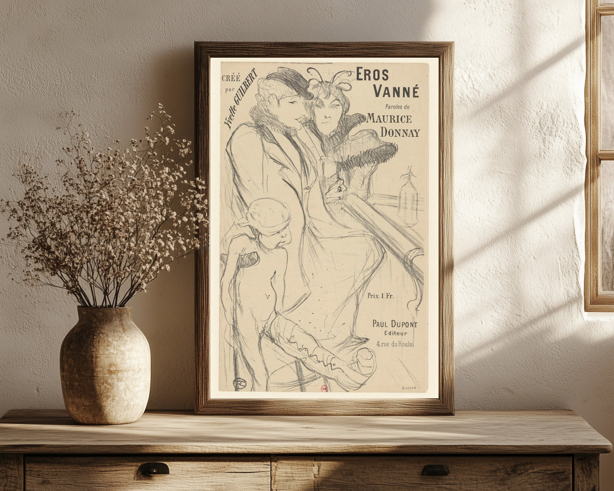 Framed art print of Eros Vanné by Henri de Toulouse-Lautrec, in a dark wood frame leaning on a rustic console beside dried flowers