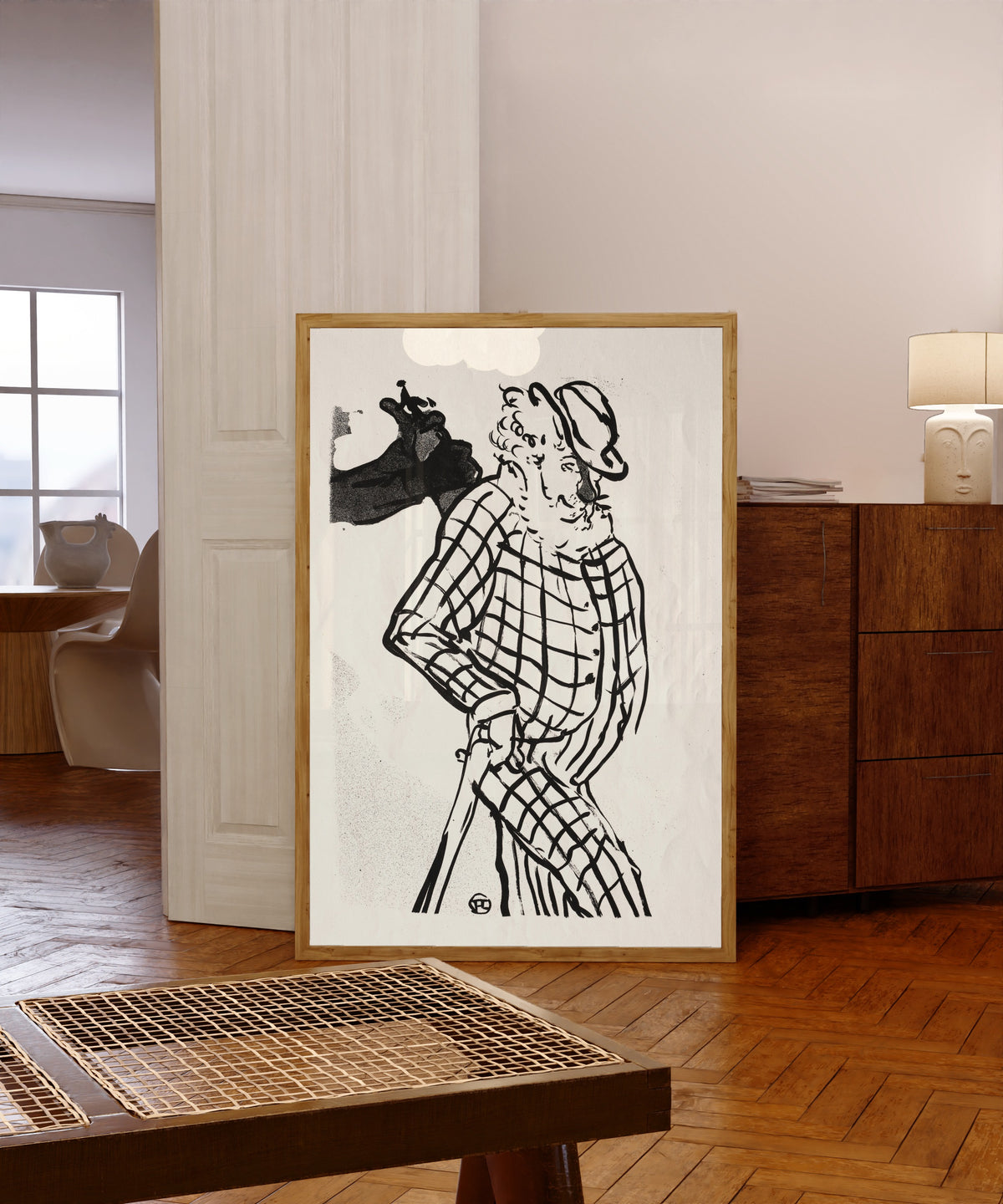 Framed art print of Le Café-Concert: American Singer by Henri de Toulouse-Lautrec, in a light wood frame leaning in a warm room with a parquet floor