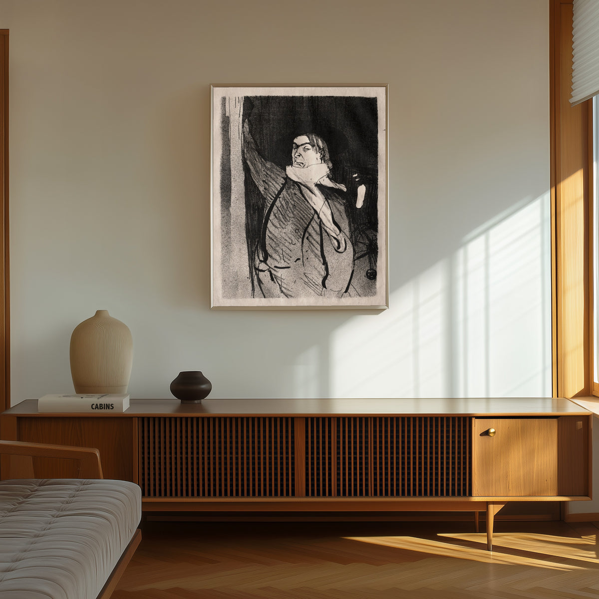 Framed art print of Le Café-Concert: Aristide Bruant by Henri de Toulouse-Lautrec, in a thin light frame on a sunlit wall above a wooden sideboard