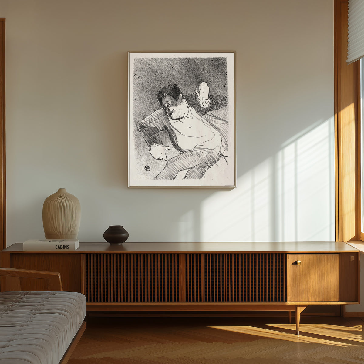 Framed art print of Le Café-Concert: Caudieux by Henri de Toulouse-Lautrec, in a thin light frame on a sunlit wall above a wooden sideboard