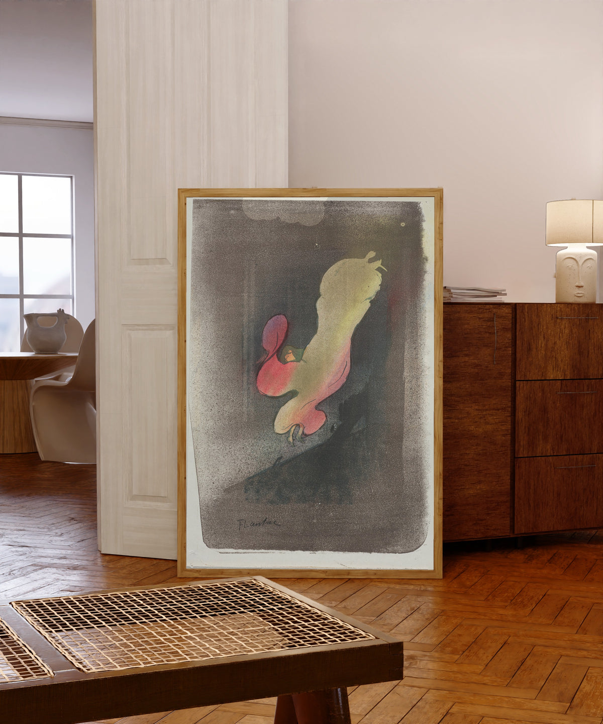 Framed art print of Miss Loïe Fuller by Henri de Toulouse-Lautrec, in a light wood frame leaning in a warm room with a parquet floor