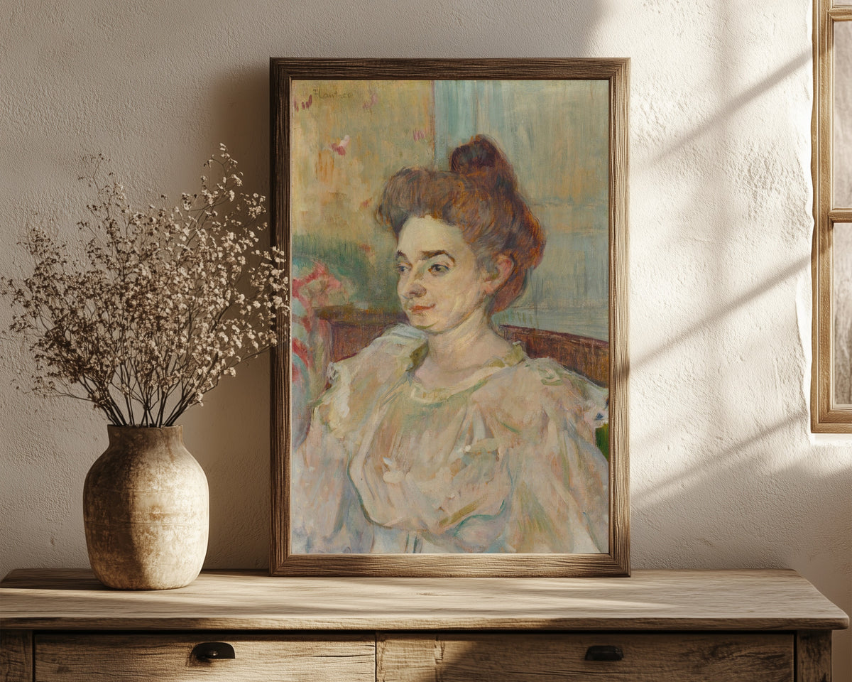 Framed art print of Portrait de Béatrice Tapié de Céleyran by Henri de Toulouse-Lautrec, in a dark wood frame leaning on a rustic console beside dried flowers