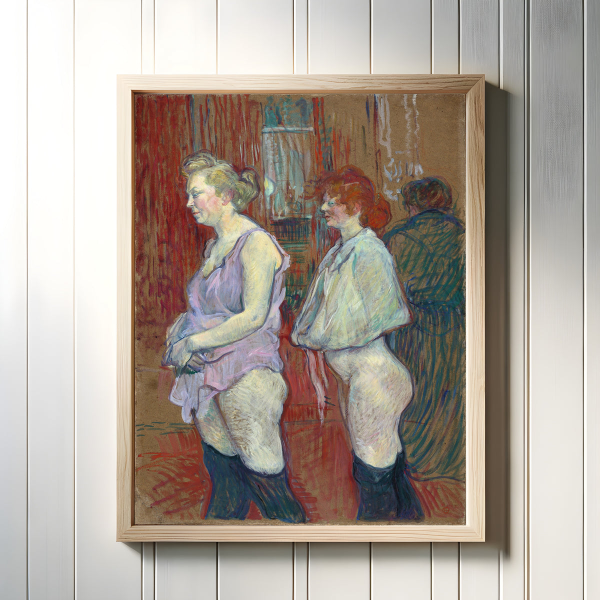 Framed art print of Rue des Moulins by Henri de Toulouse-Lautrec, in a light wood frame on a white panelled wall