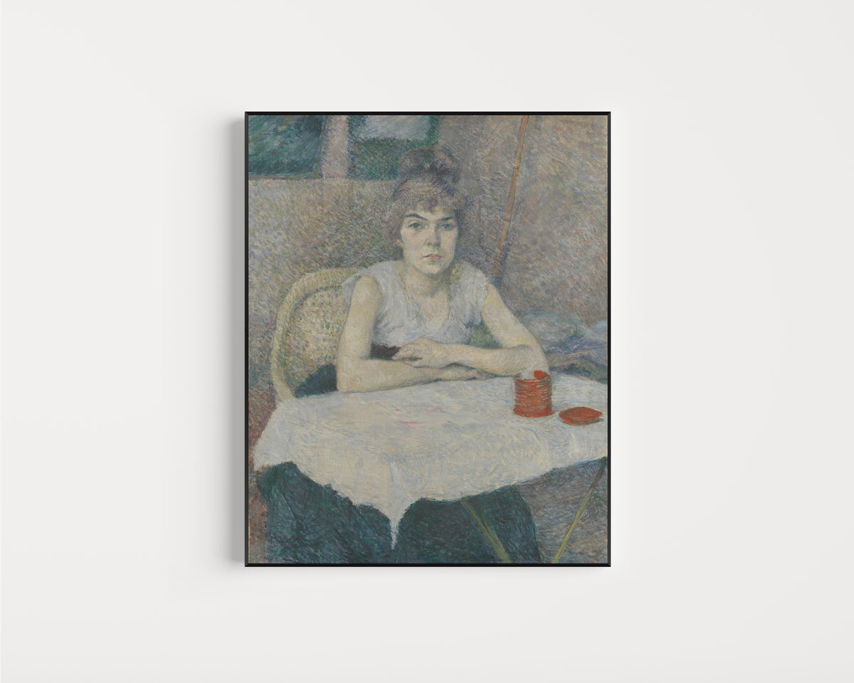 Framed art print of Young Woman at a Table, 'Poudre de riz' by Henri de Toulouse-Lautrec, in a slim black frame on a plain white wall