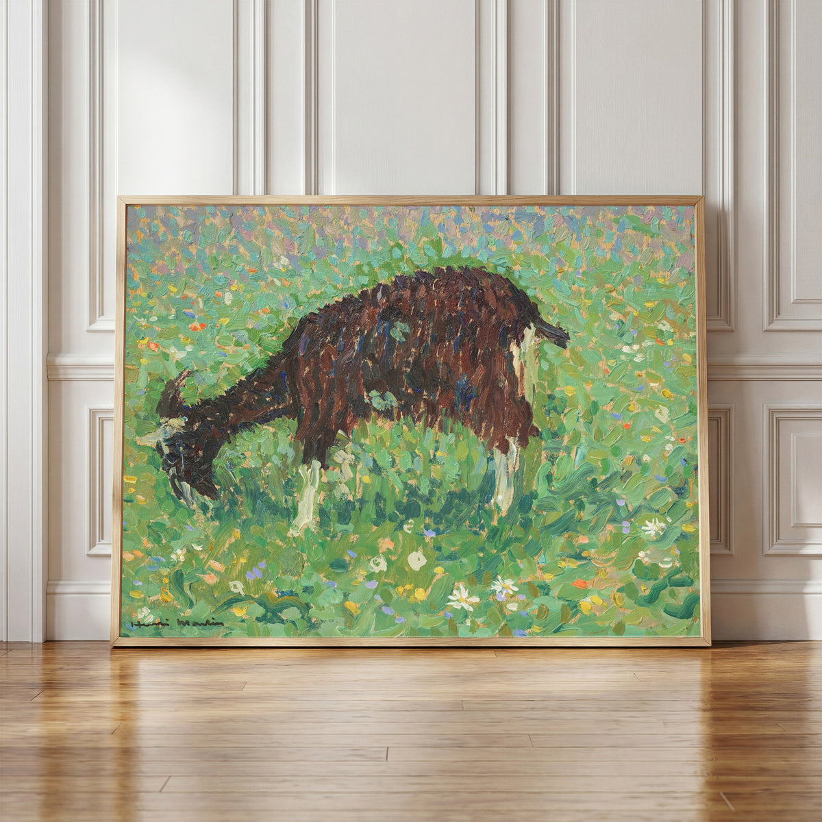 Framed art print of Chèvre dans un champ de fleurs by Henri Martin, in a light wood frame leaning against a panelled white wall